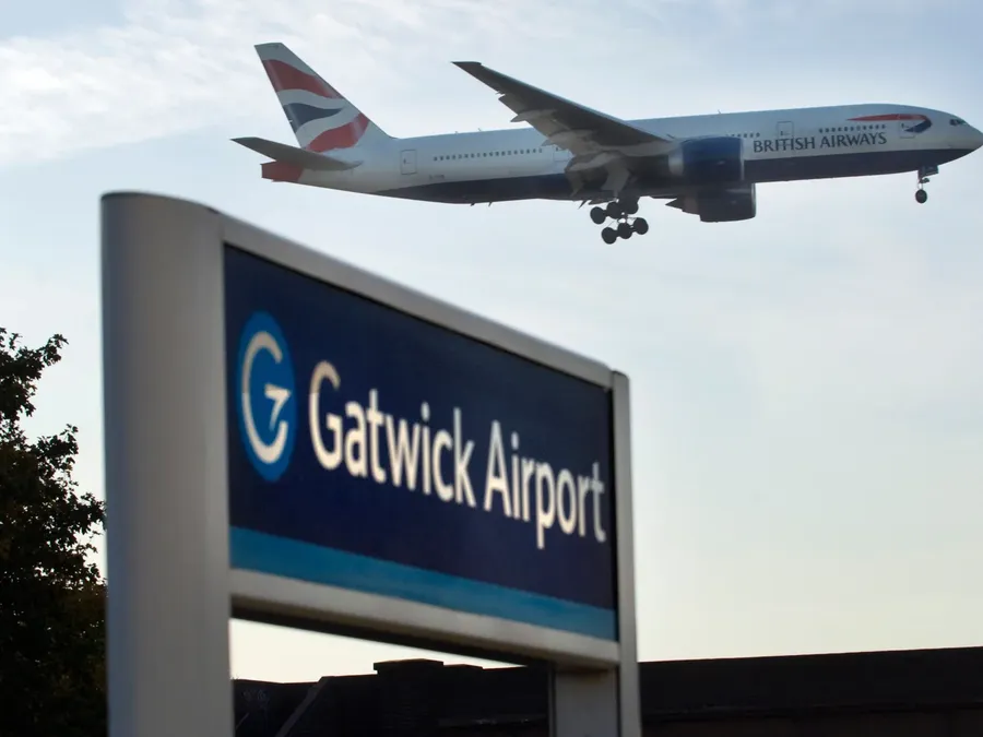 Gatwick Airport sign with a jet overhead